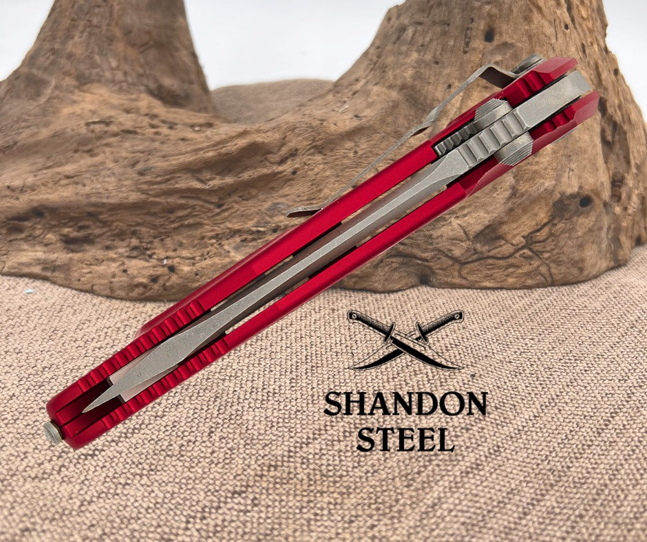 Red and silver multitool on a textured surface with 'Shandon Steel' branding.