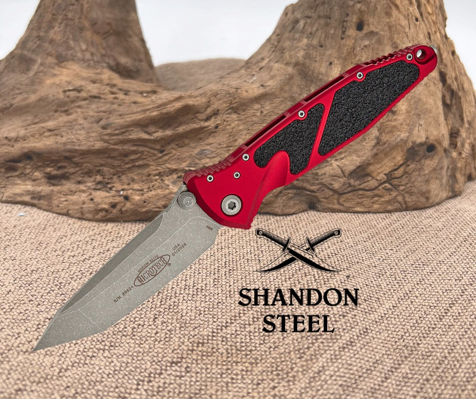 Red folding knife with black textured handle on a textured surface, Primemartshop logo visible